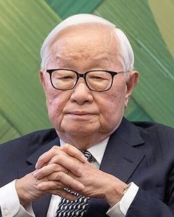 Morris Chang, white-haired and in glasses, seated with his hands clasped in front of him